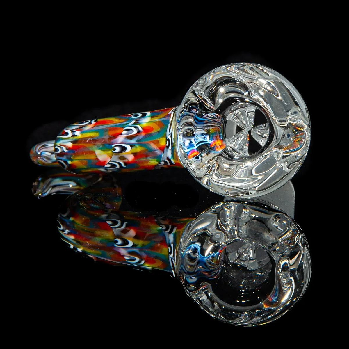 Colorful glass hand pipe with clear bowl, vibrant patterns, and reflective black background