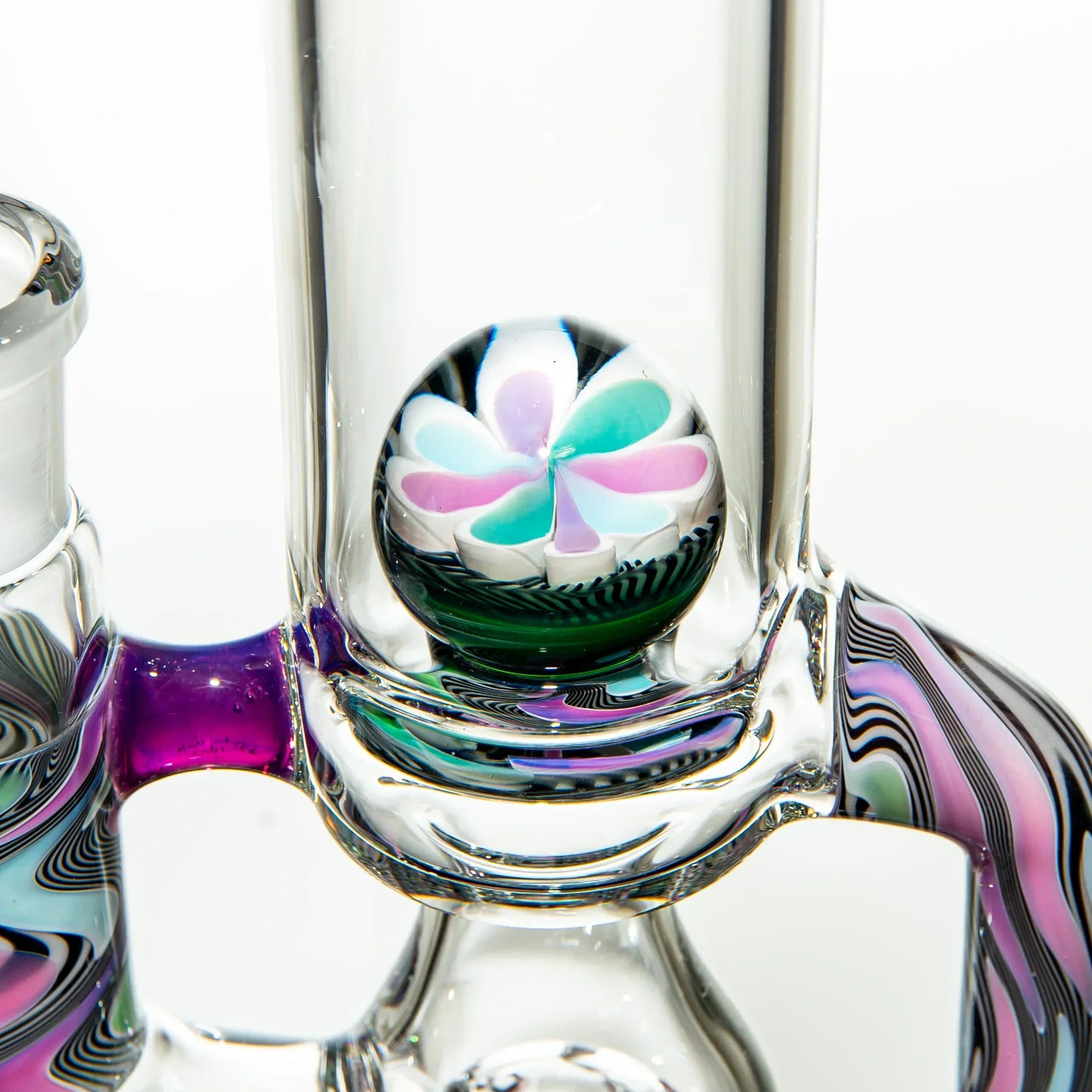 Close-up of colorful heady glass water pipe with flower marble accent and swirling patterns