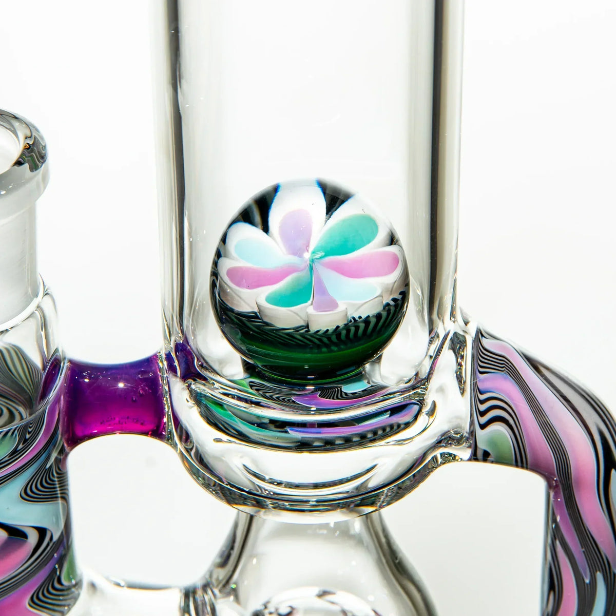 Close-up of colorful heady glass water pipe with flower marble accent and swirling patterns