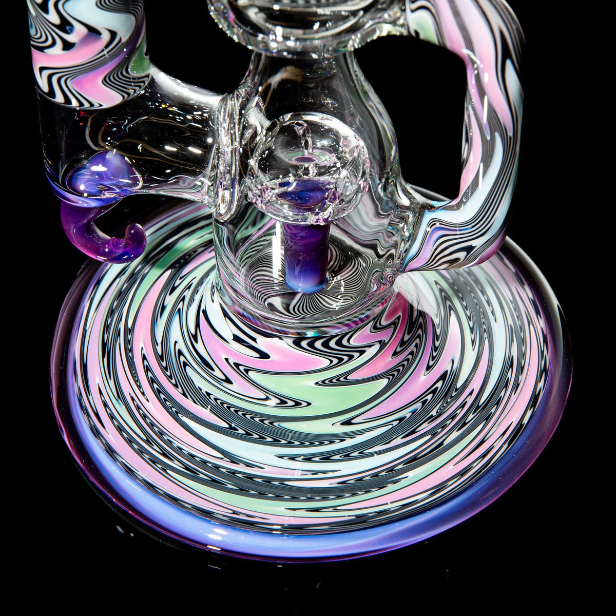 Colorful heady glass water pipe with intricate swirled patterns on black background