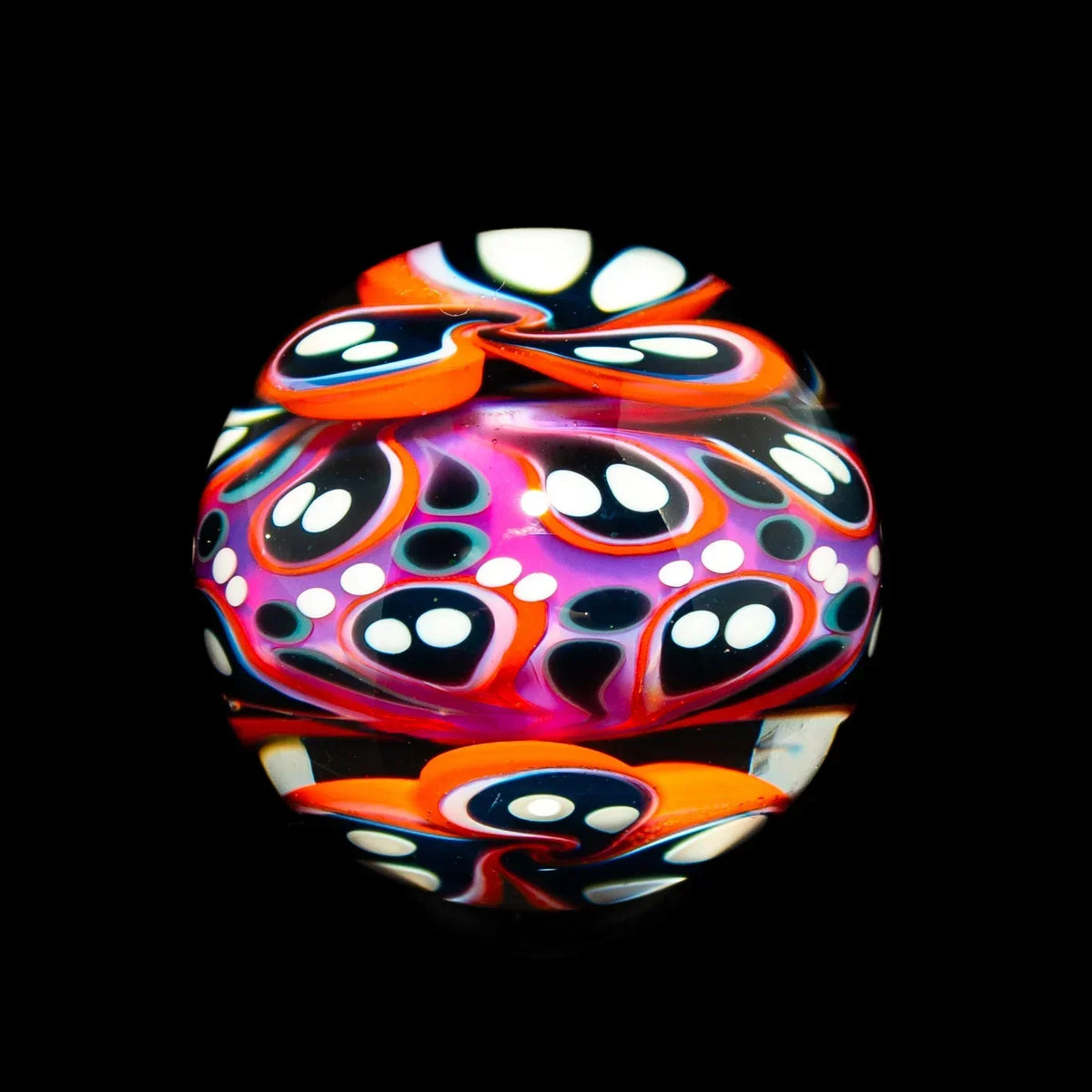 Colorful hand-blown glass art marble with magenta, orange, and abstract dot designs