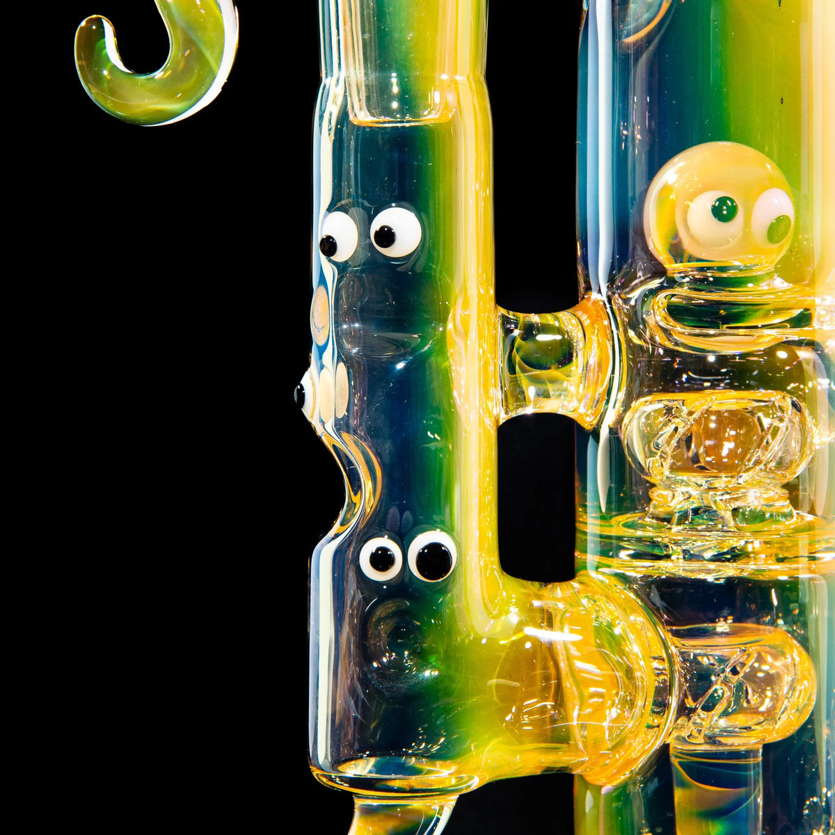 Colorful heady glass water pipe with cartoon eyes and unique character details on black background