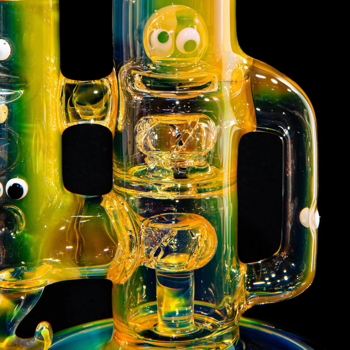 Colorful heady glass water pipe with character face and intricate design on black background