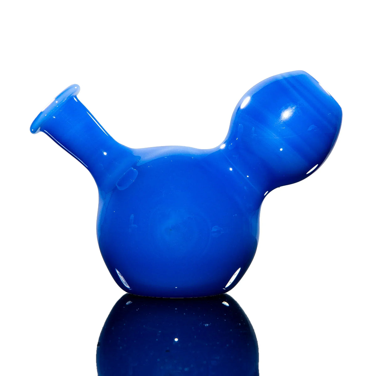 Blue glass hand pipe with unique rounded shape on reflective surface