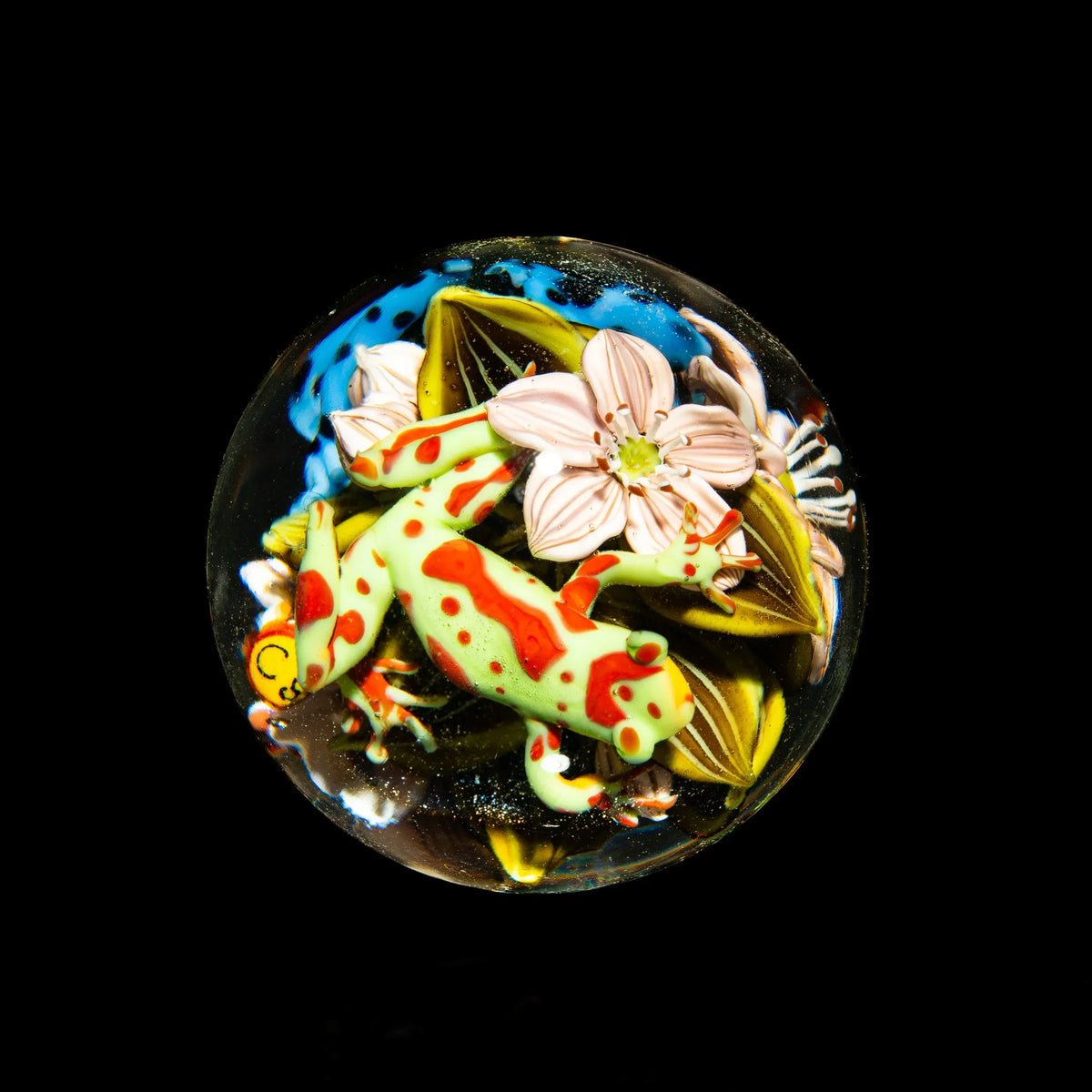 Handcrafted glass marble featuring a colorful lizard and pink flower design