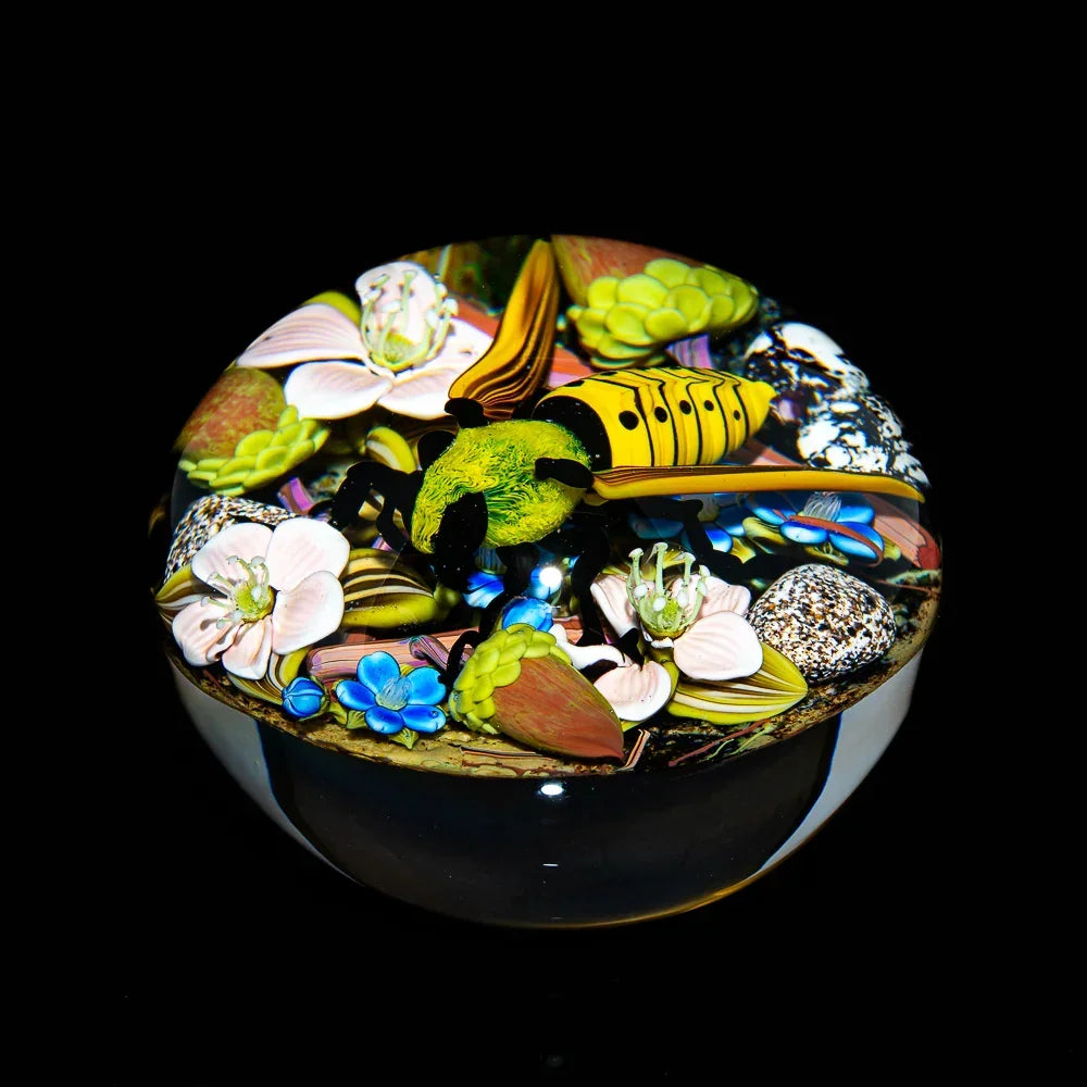 Handcrafted glass art featuring a yellow bee on colorful flowers with intricate details