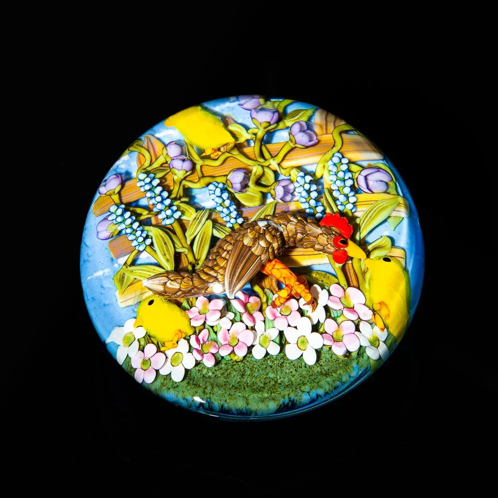 Glass art piece featuring a chicken, flowers, and chicks in a colorful, detailed scene