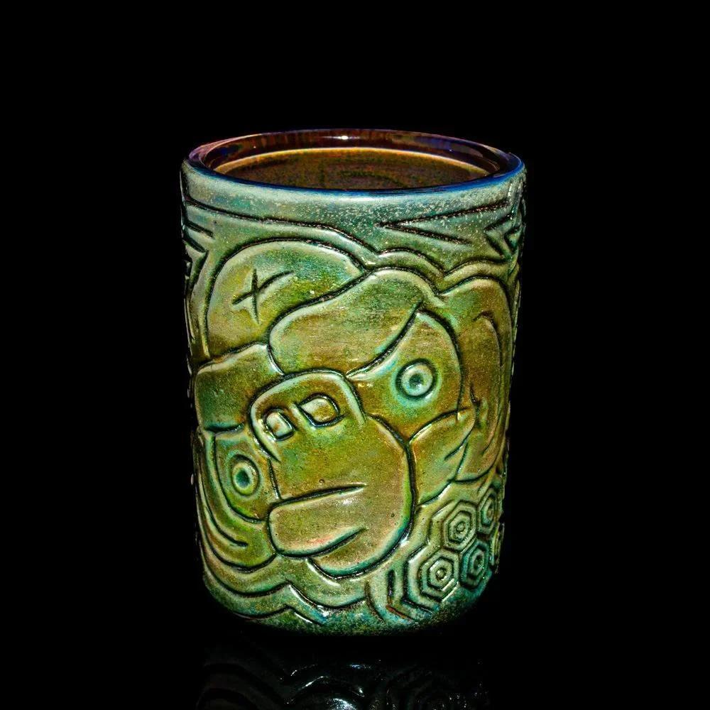 Handcrafted ceramic candle holder with embossed gorilla face design on black background