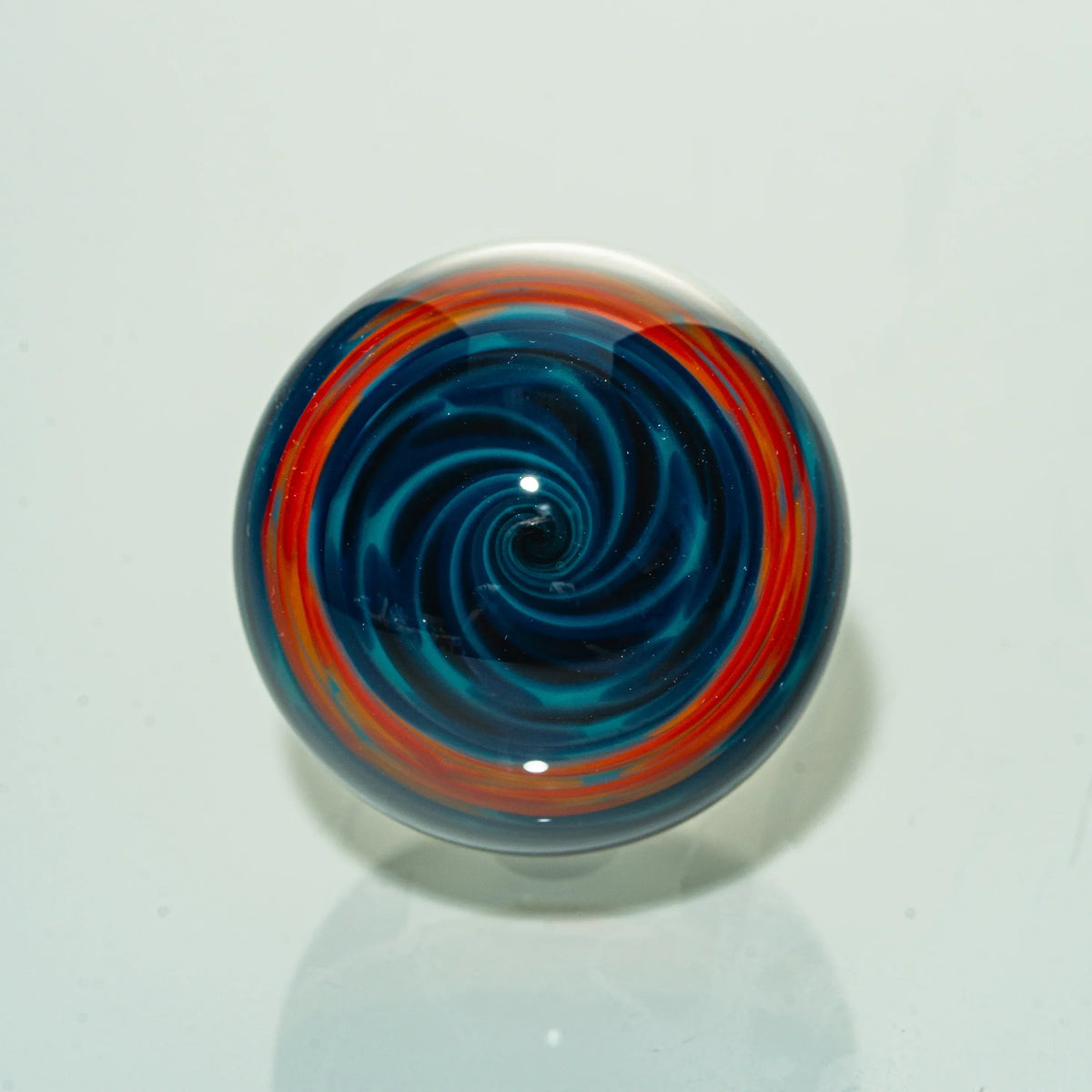 Colorful heady glass marble with blue and red spiral design, smoking accessory