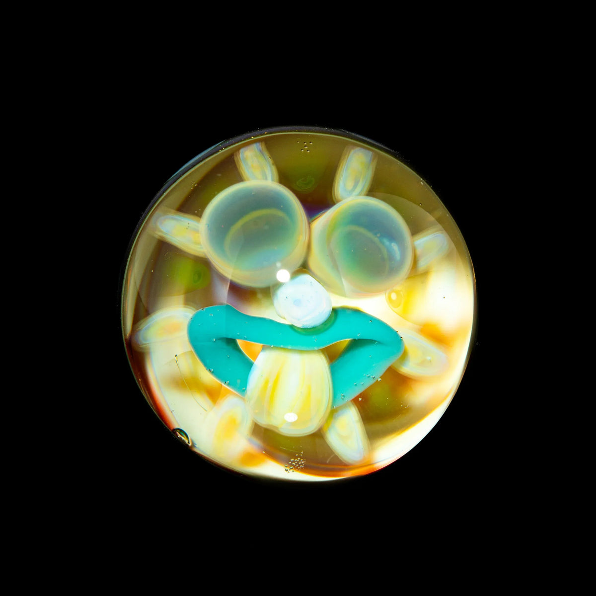 Colorful glass marble with a whimsical face design on black background, art glass accessory