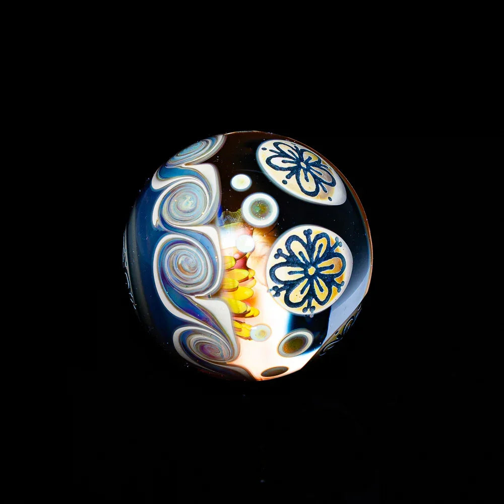 Heady glass marble with intricate floral and swirl designs on a black background