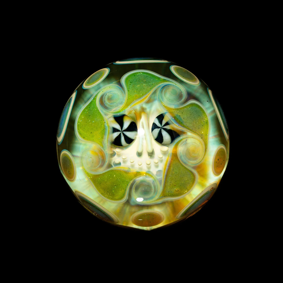 Heady glass marble with colorful skull design and psychedelic swirls on a black background