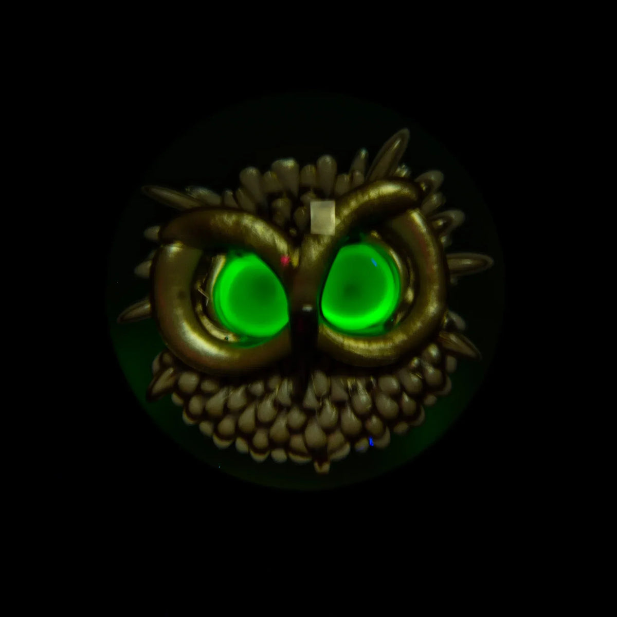 Glass owl pendant with glowing green eyes on black background, heady glass accessory