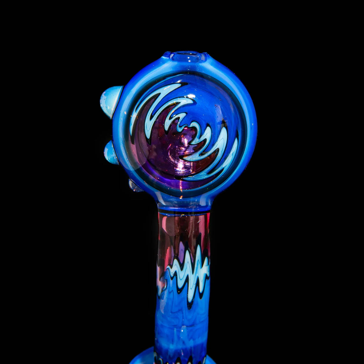 Blue glass hand pipe with wavy patterns and artistic design on black background