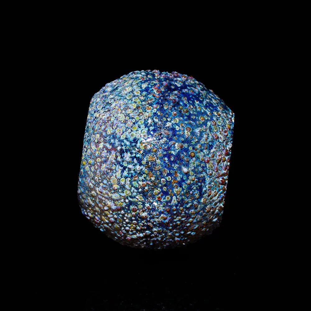 Colorful textured glass carb cap with multicolored dots on a black background
