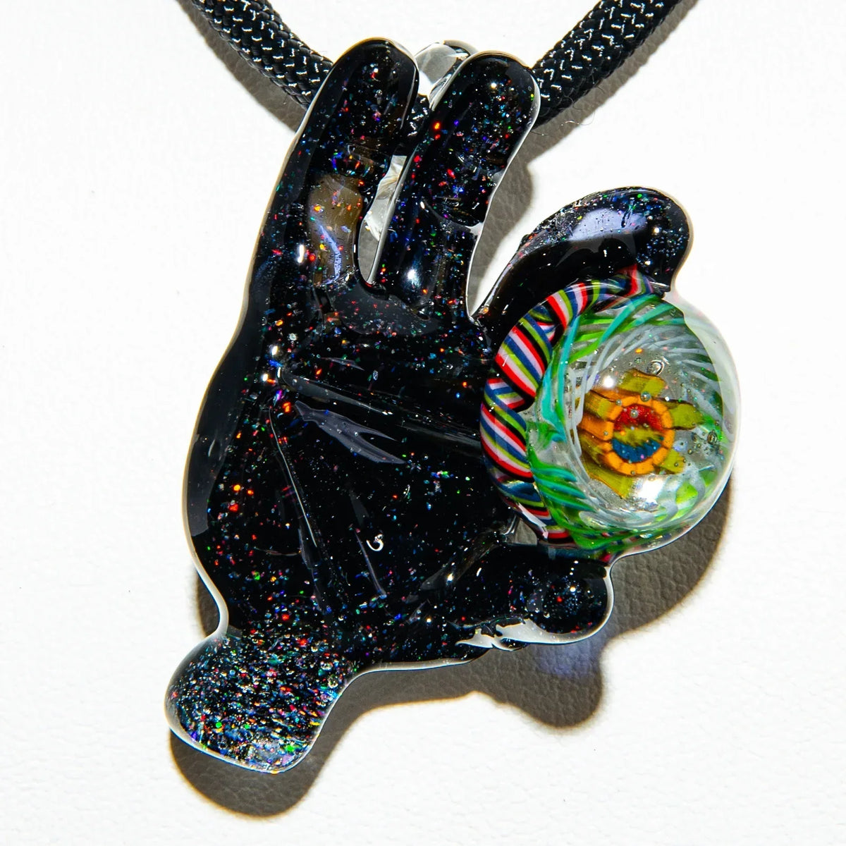 Hand-shaped glass pendant with colorful marble accent and glitter details