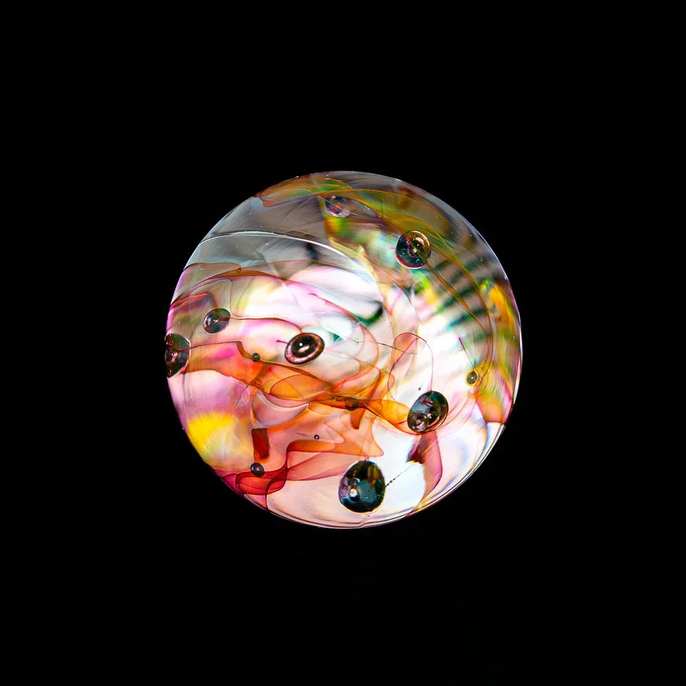 Colorful artistic glass marble with swirled patterns and bubbles on a black background