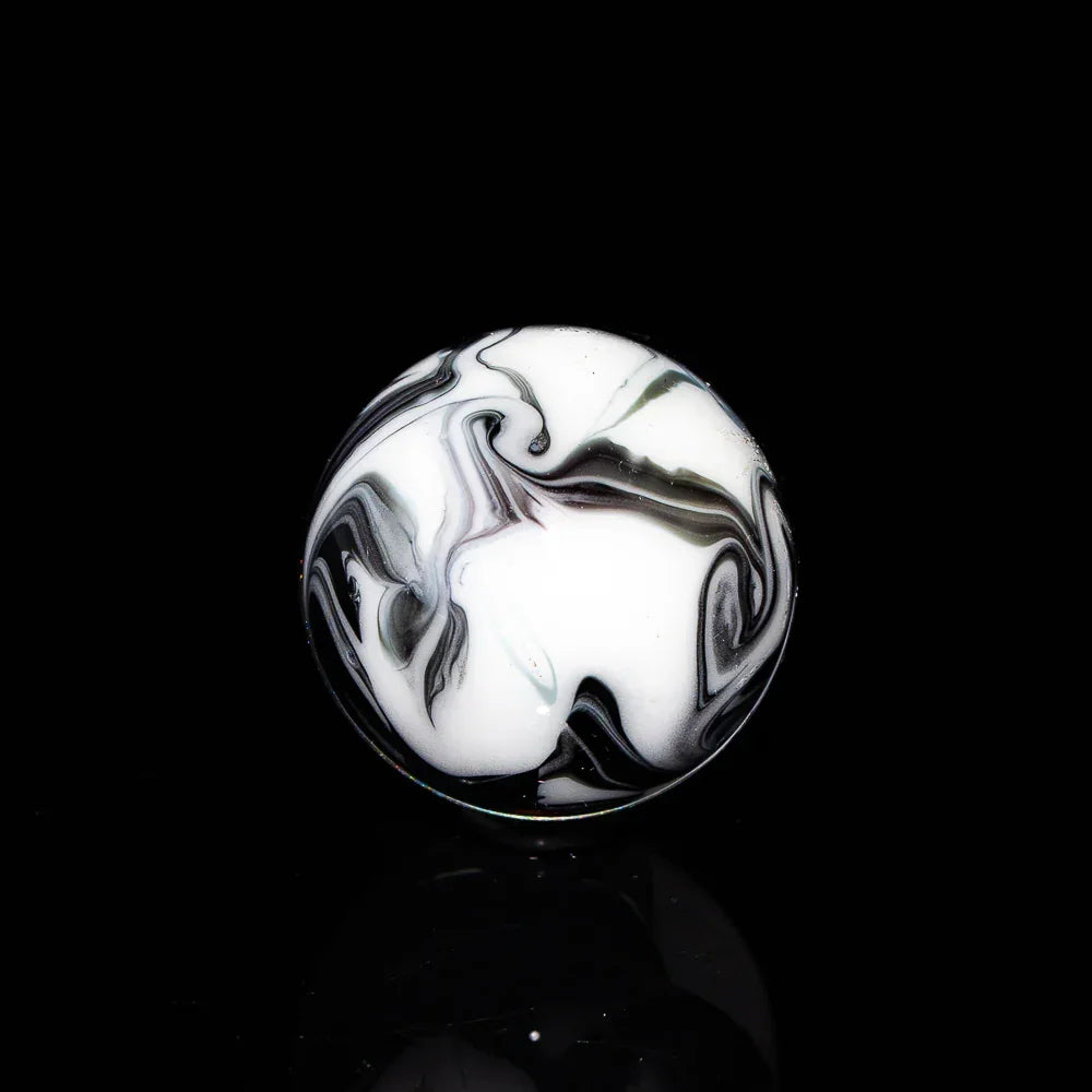 Black and white glass marble with swirling pattern on a black background
