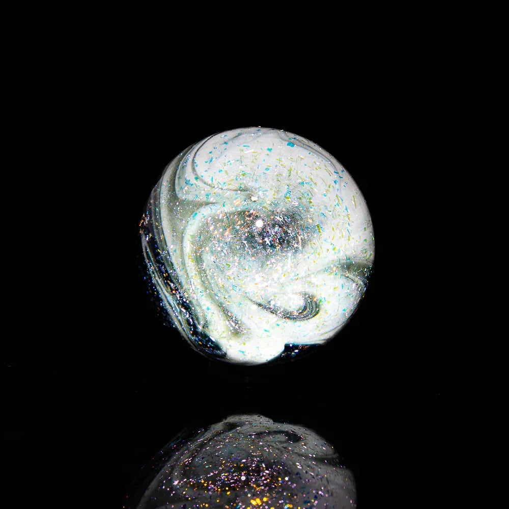 Heady glass marble with swirling white patterns and iridescent glitter on black background