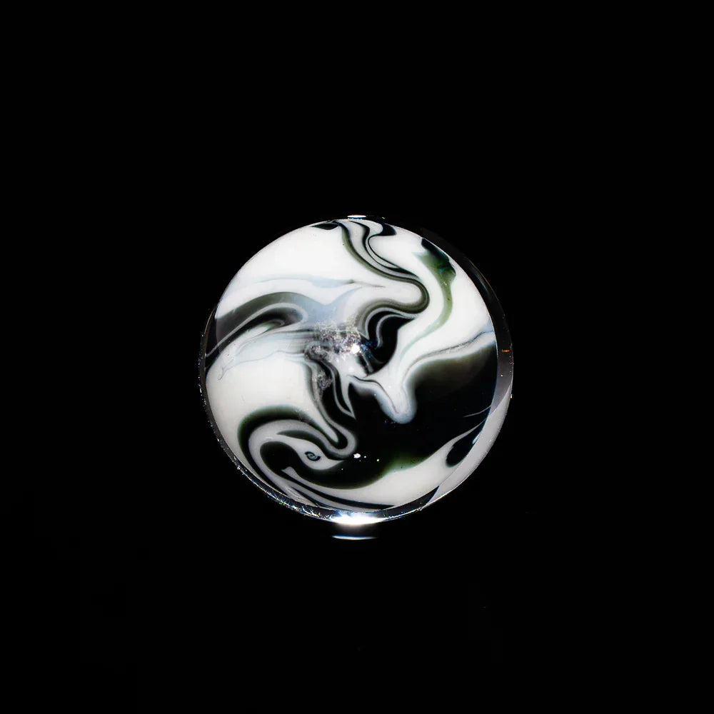 Black and white glass marble with swirling pattern on a black background