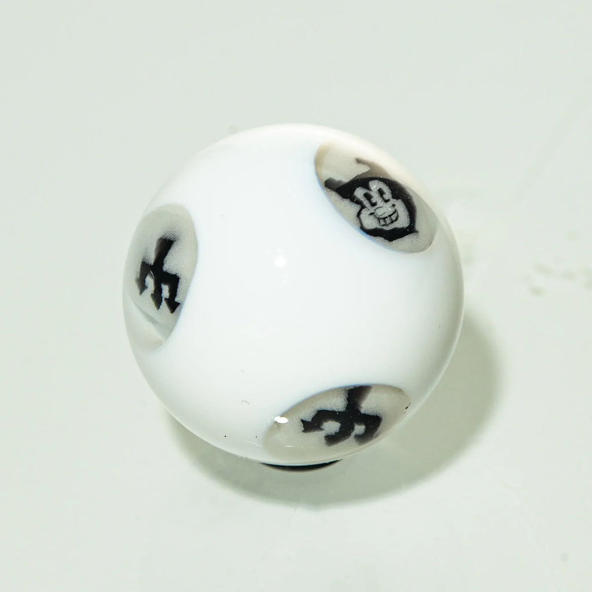 White glass marble with black cartoon face and abstract designs, art glass accessory