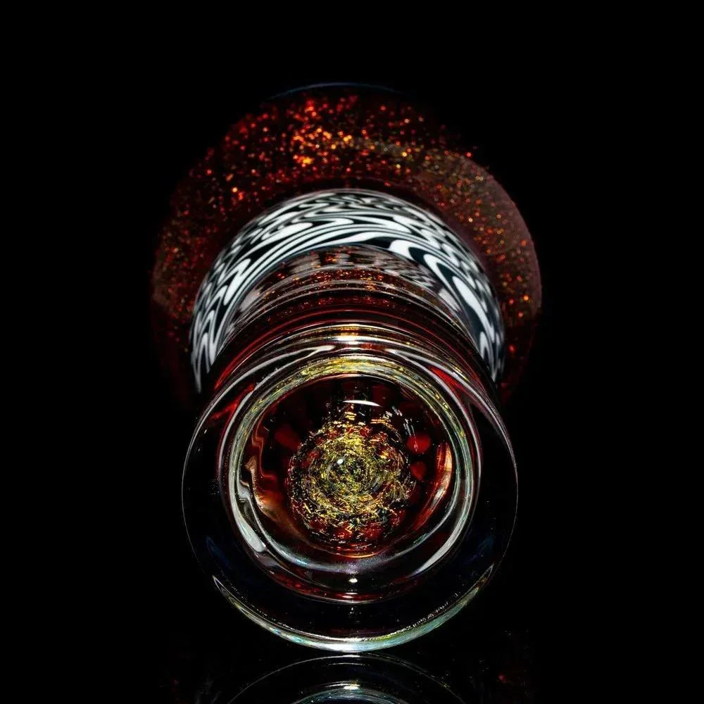 Close-up of a heady glass pipe with intricate patterns and shimmering red accents on black