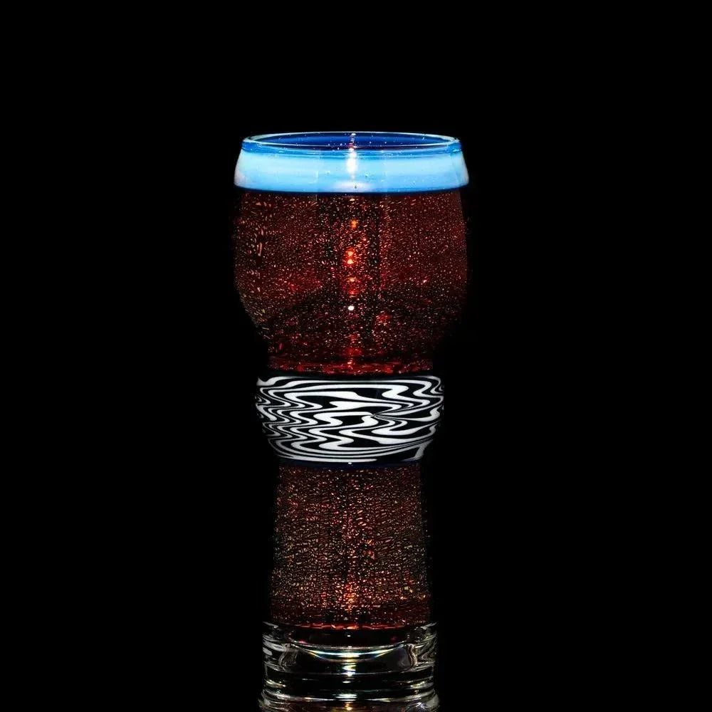 Hand-blown glass cup with red and black swirling pattern and blue rim on black background