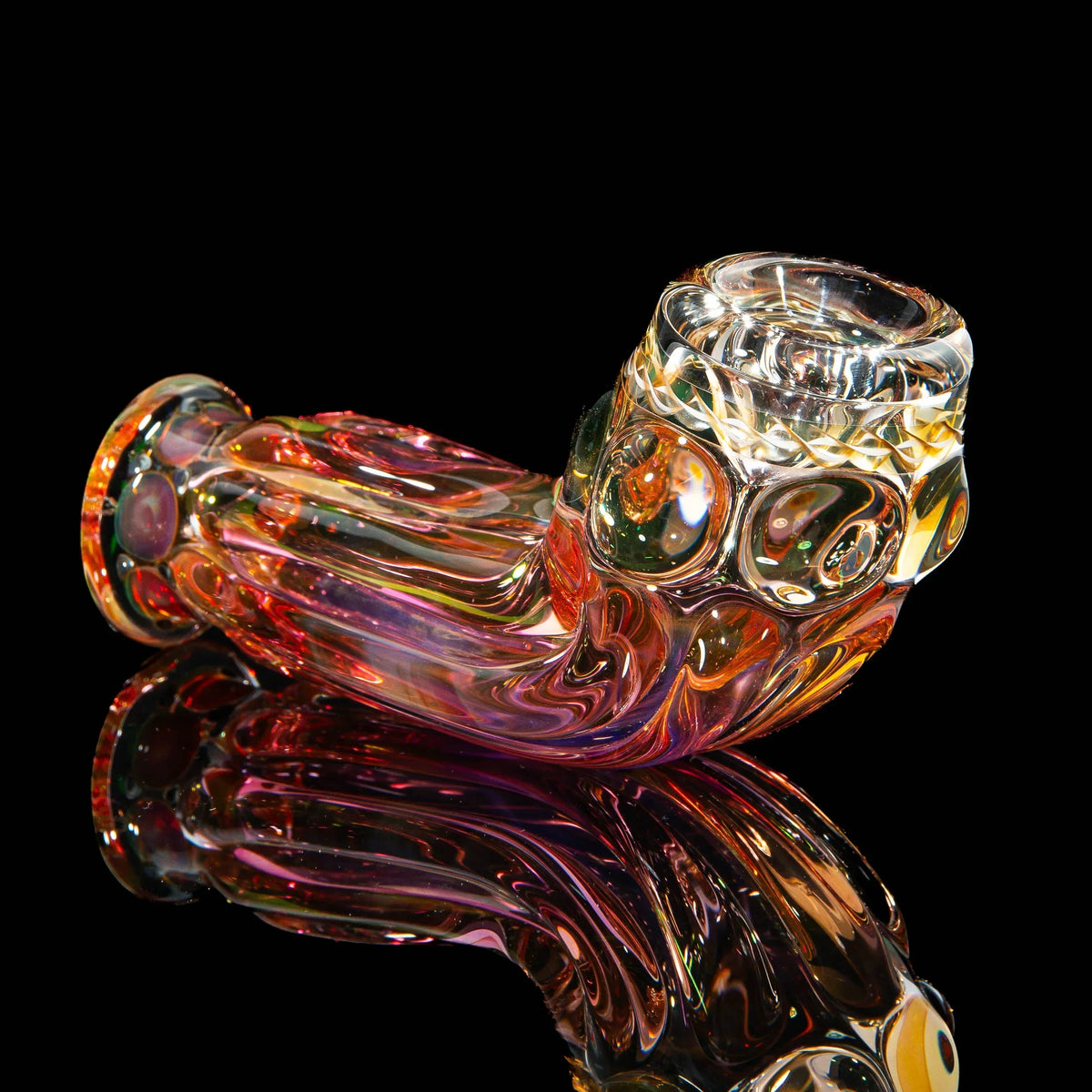 Colorful art glass hand pipe with textured design, displayed on a black reflective surface