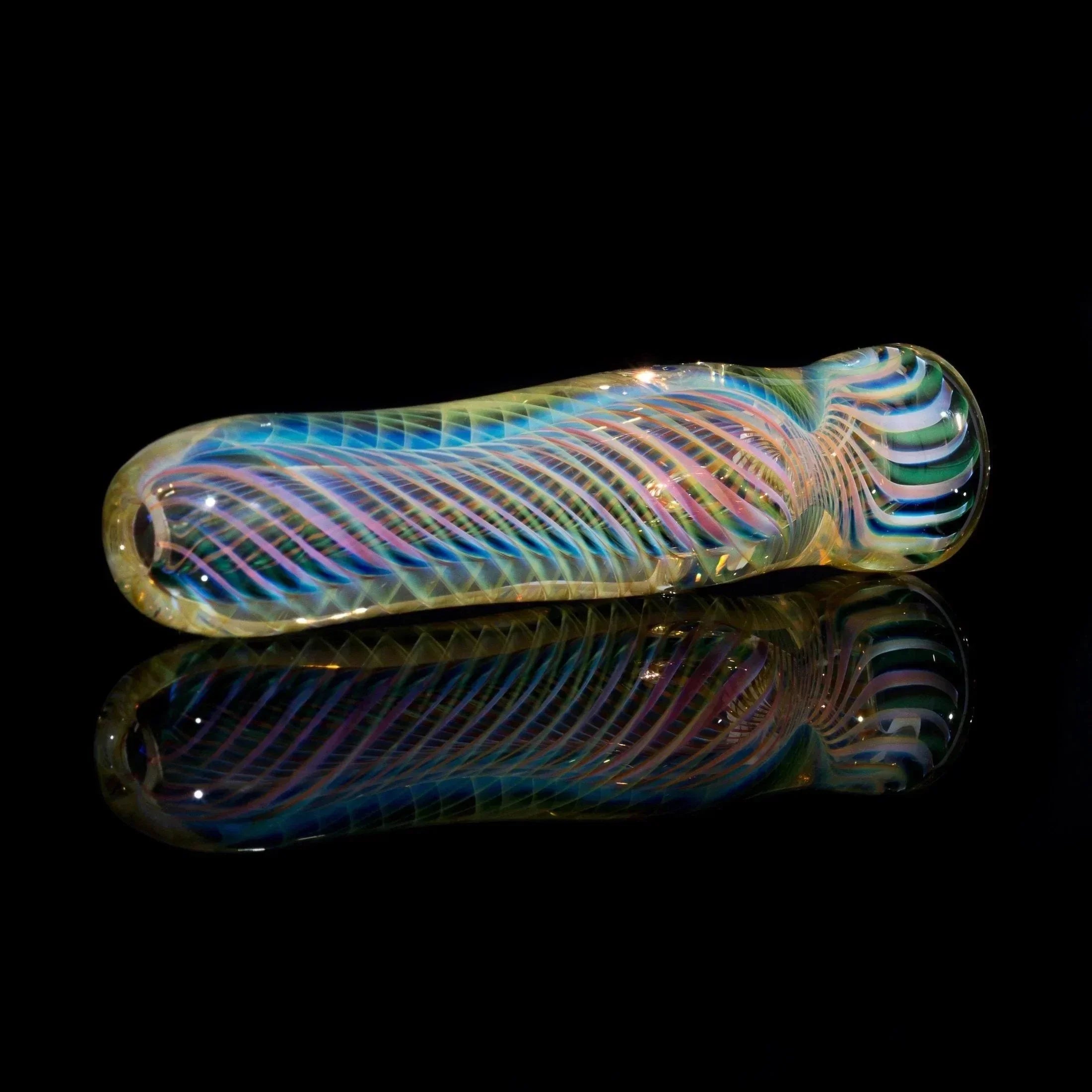 Colorful hand-blown glass pipe with swirling patterns on a black reflective surface