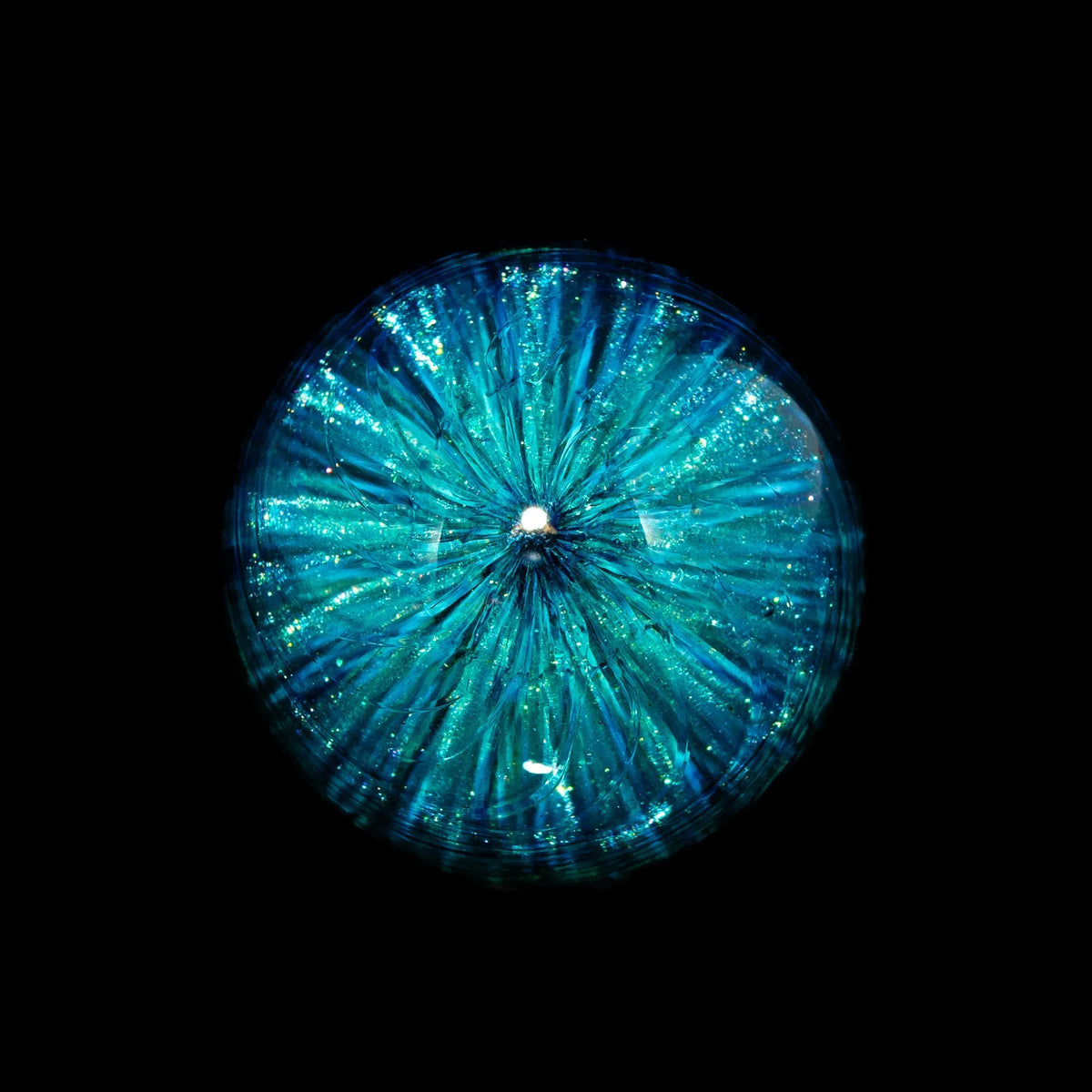 Blue and teal heady glass marble with sparkling, intricate internal design on black background