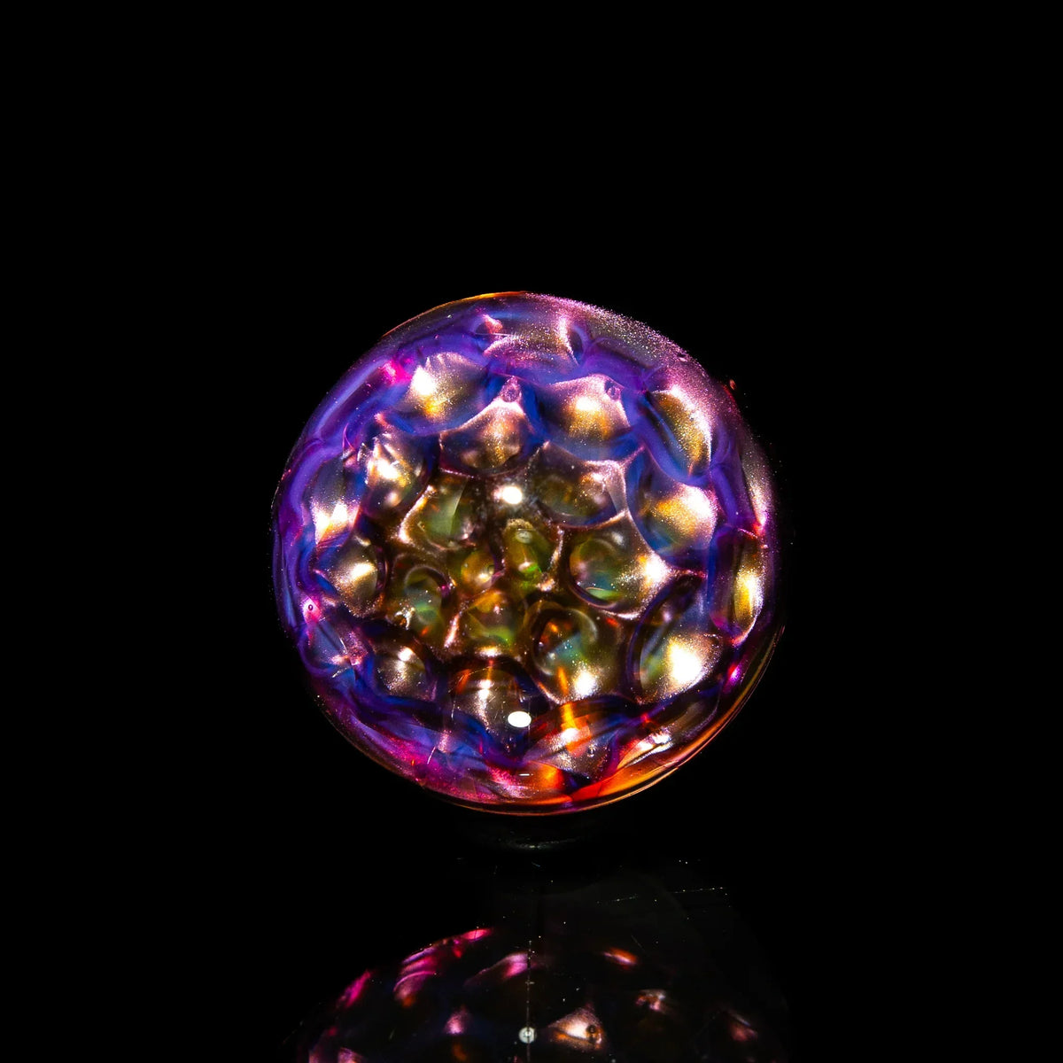 Colorful glass carb cap with honeycomb pattern on black background