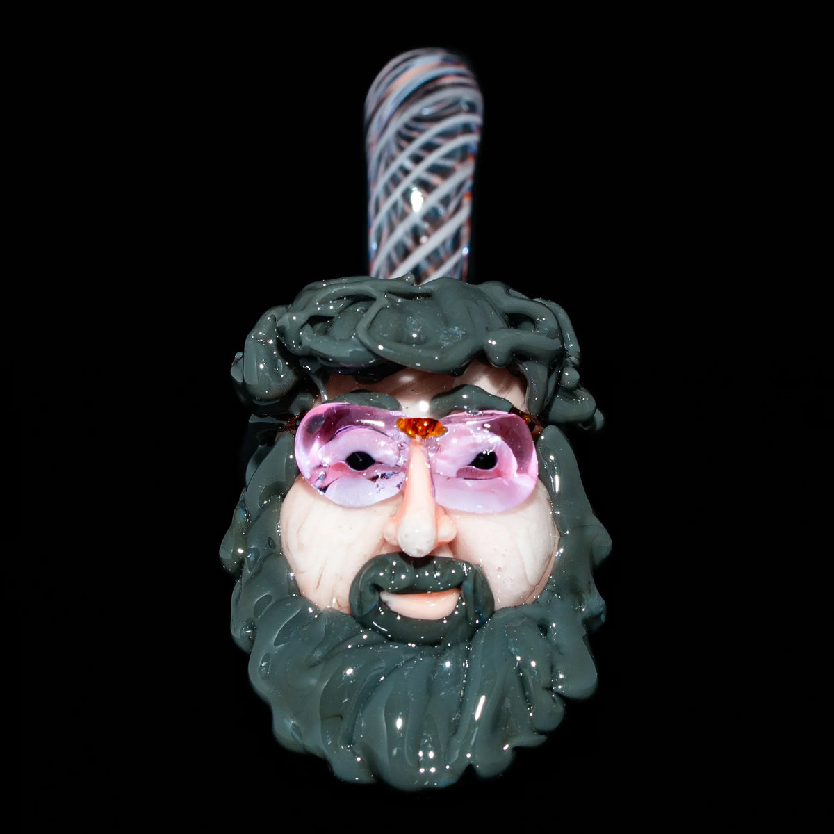 Hand-blown glass pipe shaped like a bearded face with sunglasses on a black background