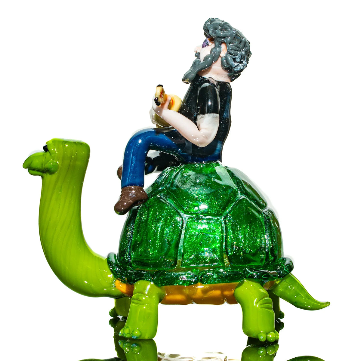 Handcrafted glass figurine of a bearded man playing guitar while riding a green turtle.
