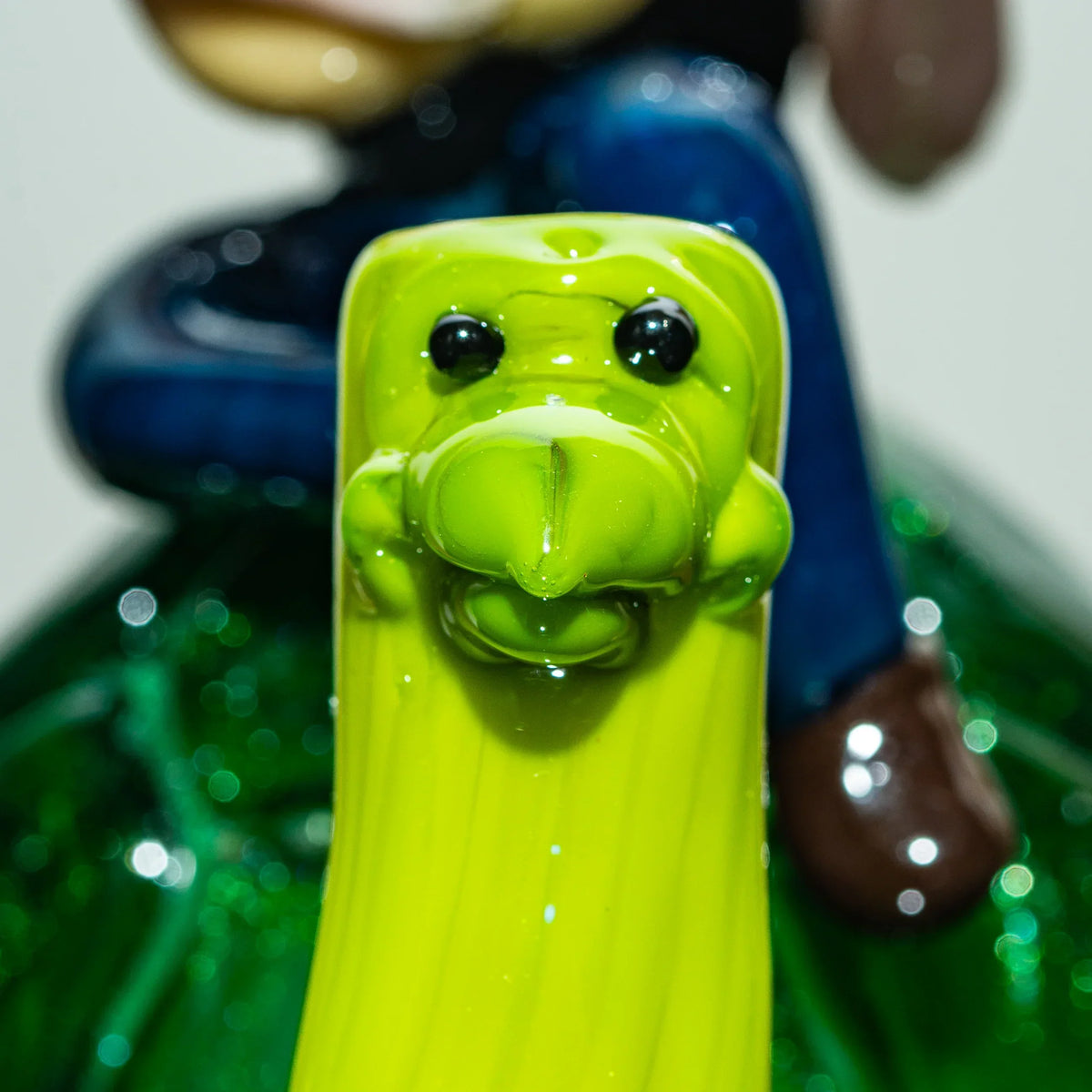 Close-up of a bright green glass turtle sculpture with intricate detailing