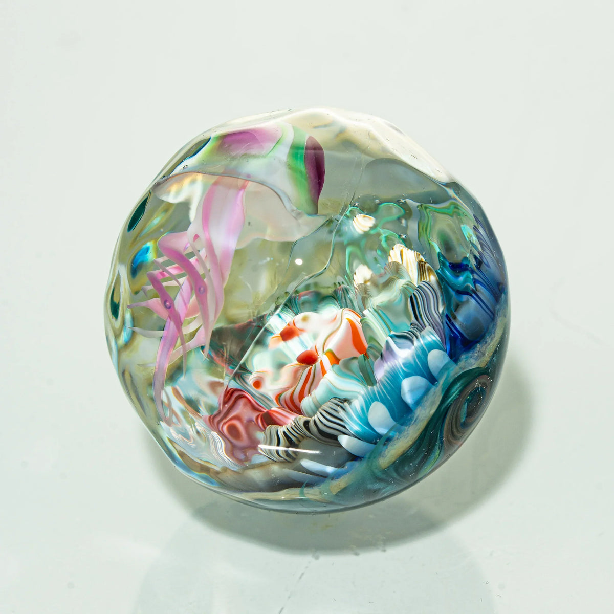 Hand-blown glass marble with colorful jellyfish design and intricate ocean details