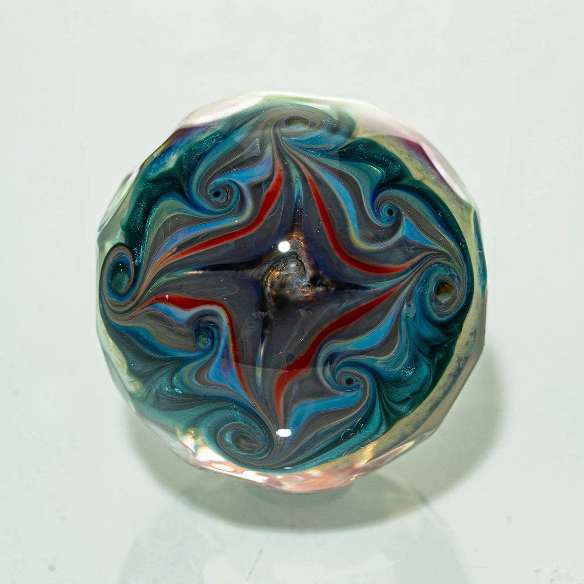 Colorful swirling heady glass art marble with vibrant red, blue, and green patterns