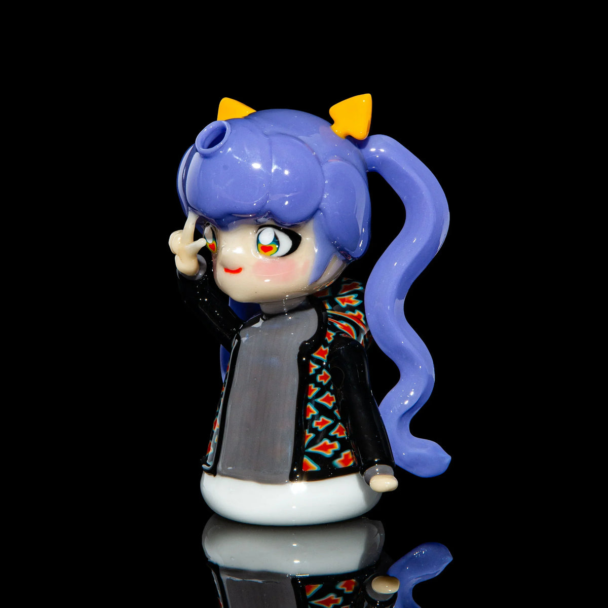 Hand-blown glass character pipe with purple hair, peace sign, and colorful jacket on black background