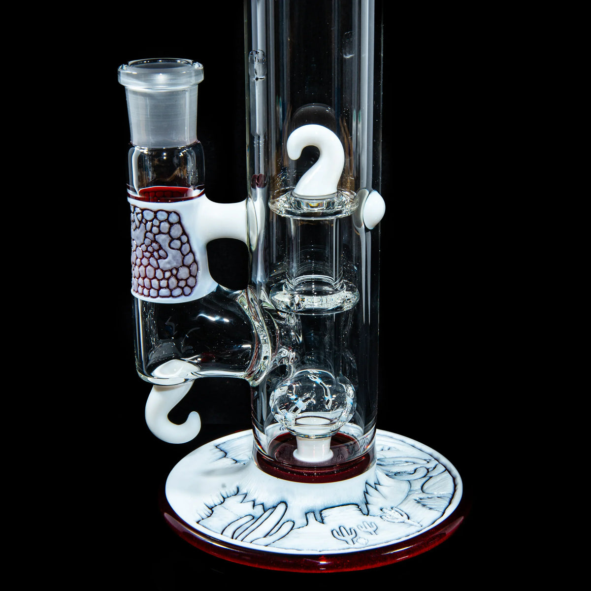 Heady glass water pipe with intricate white accents and engraved base on black background