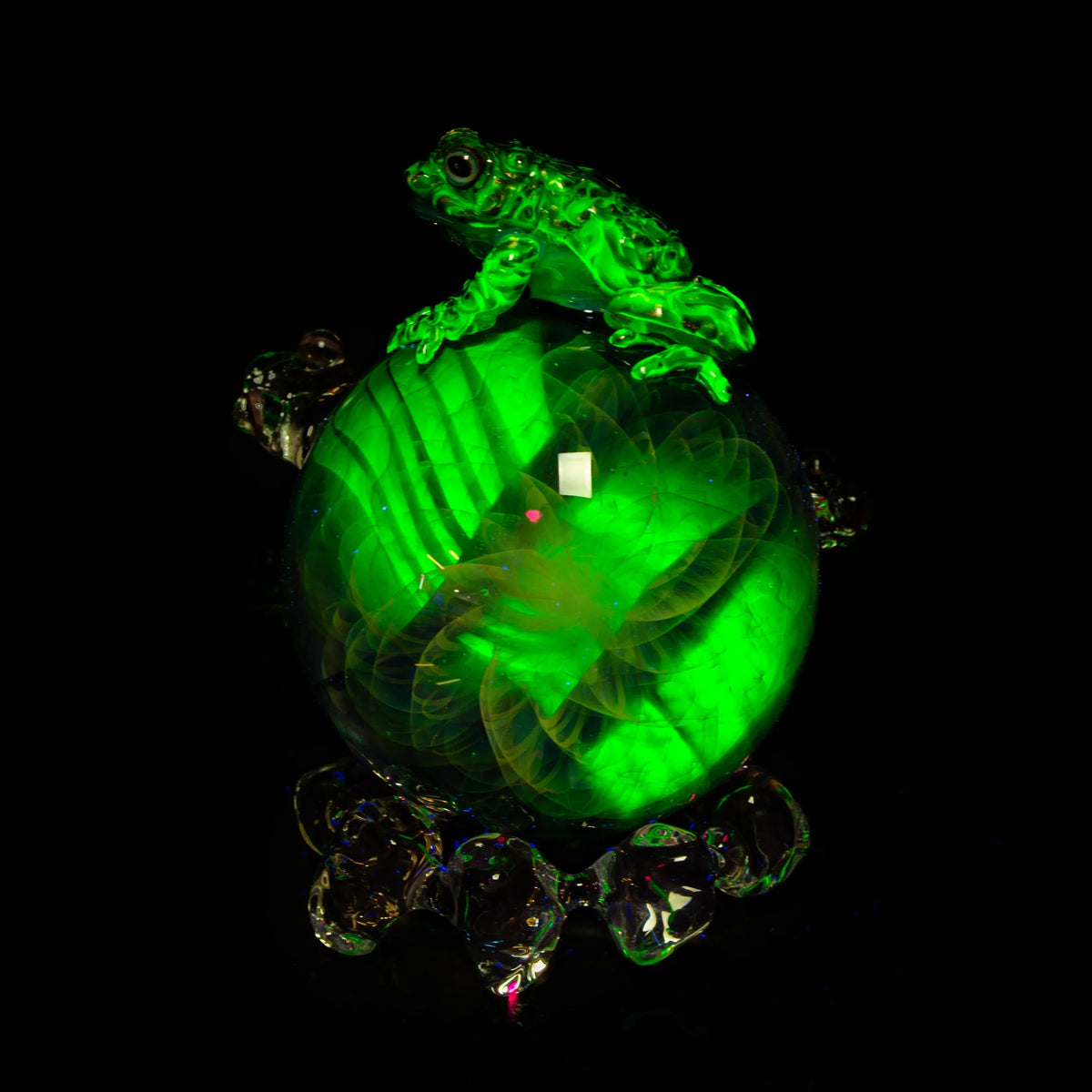 Heady glass art marble with green frog sculpture, luminous details on black background