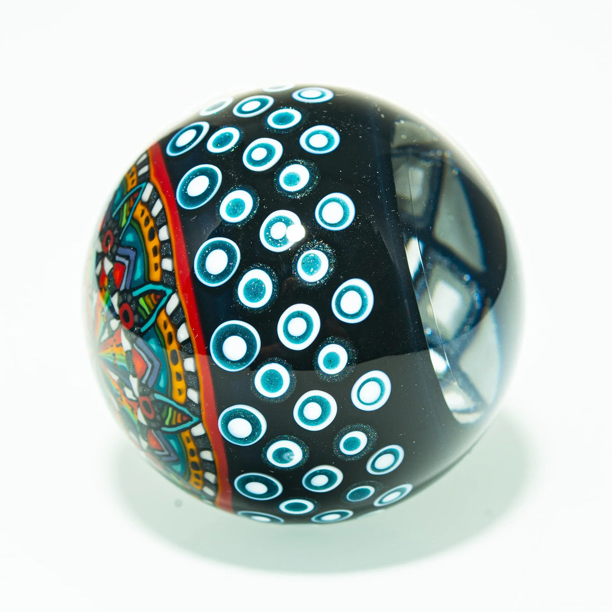 Colorful heady glass marble with geometric patterns and blue dot accents on white background