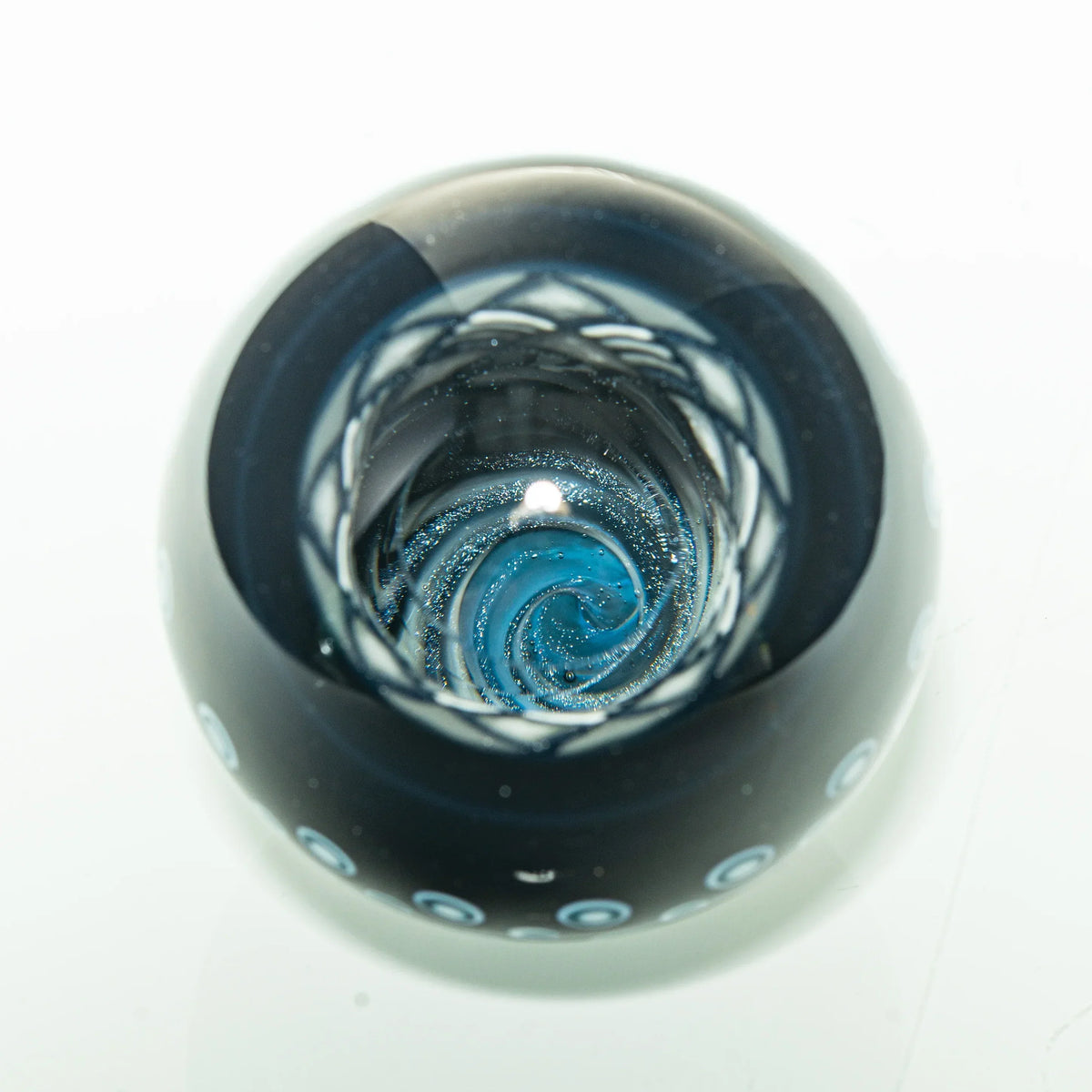 Heady glass marble with blue vortex swirl design and intricate dot patterns