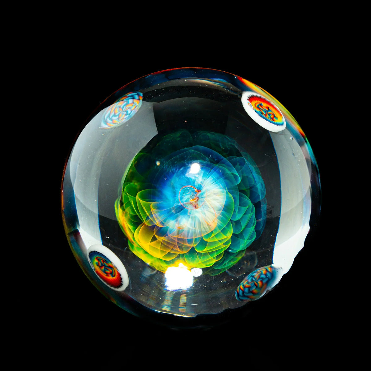 Intricate heady glass marble with colorful flower design and millefiori accents on black background