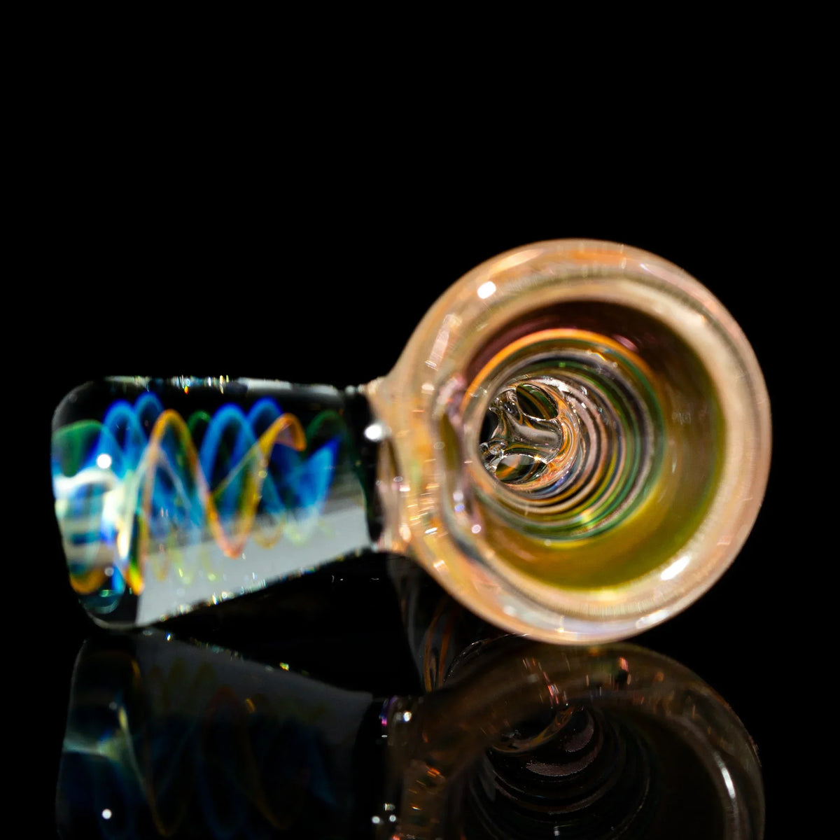 Colorful glass hand pipe with swirling patterns on black background