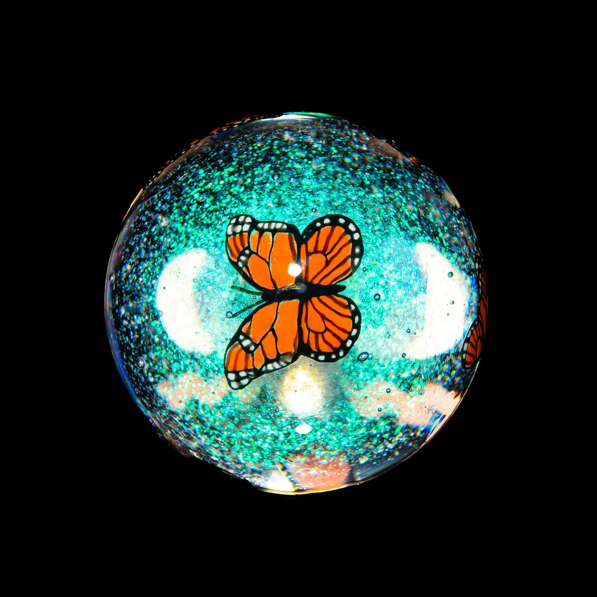 Glass marble with orange butterfly design and sparkling teal background