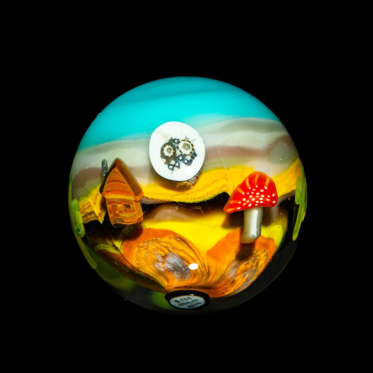 Art glass marble with mushroom, tiny house, skull, colorful landscape design on black background