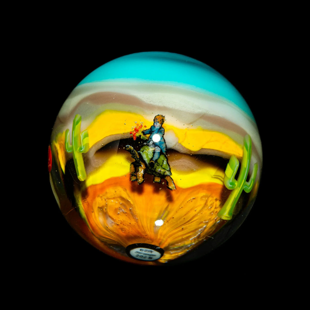 Glass marble with cowboy and cactus desert scene, vibrant colors, heady glass art