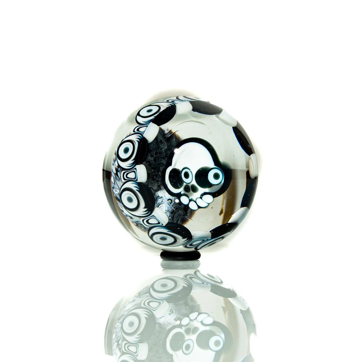 Black and white glass marble with intricate skull and geometric patterns