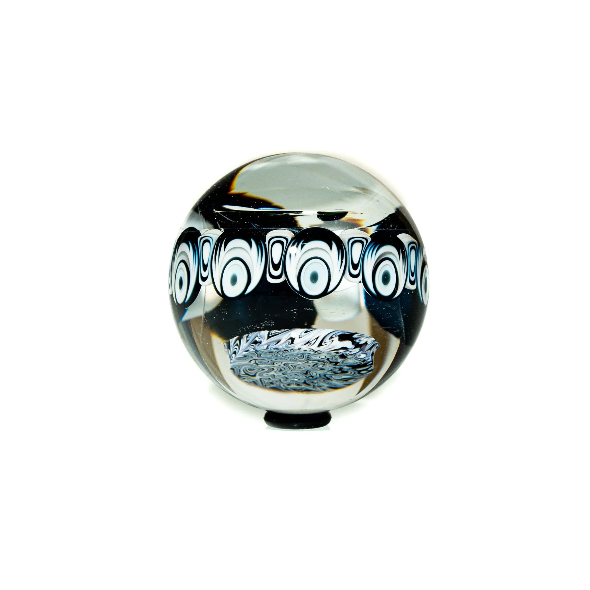 Handcrafted glass marble with black and white patterned design on a white background