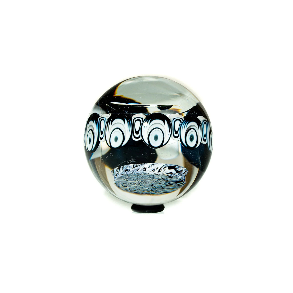 Handcrafted glass marble with black and white patterned design on a white background