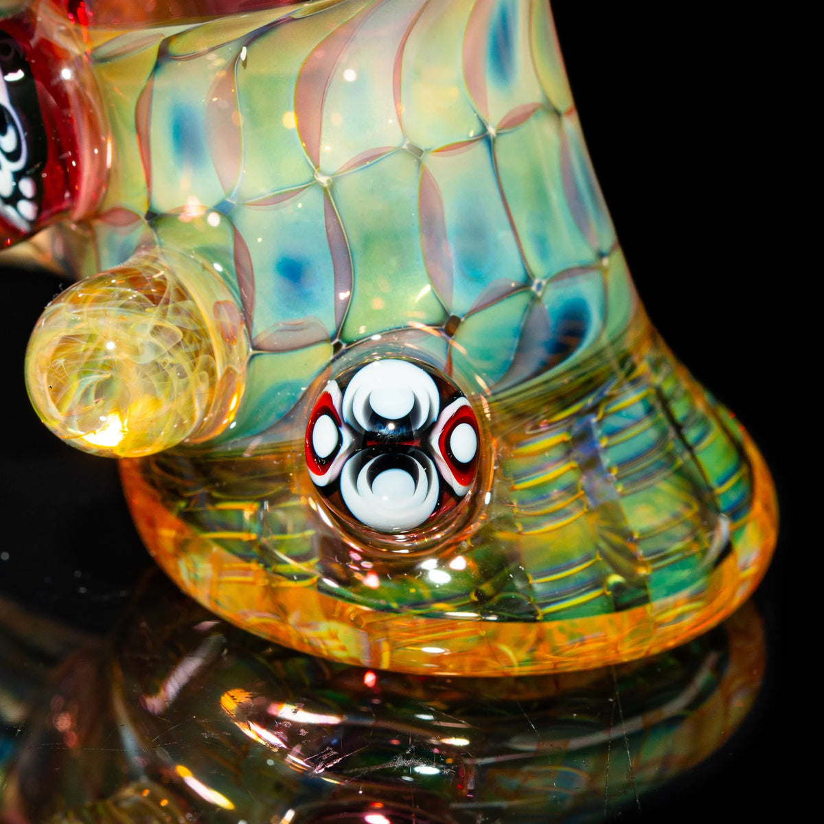 Colorful heady glass pipe with intricate patterns and decorative marbles, on black background